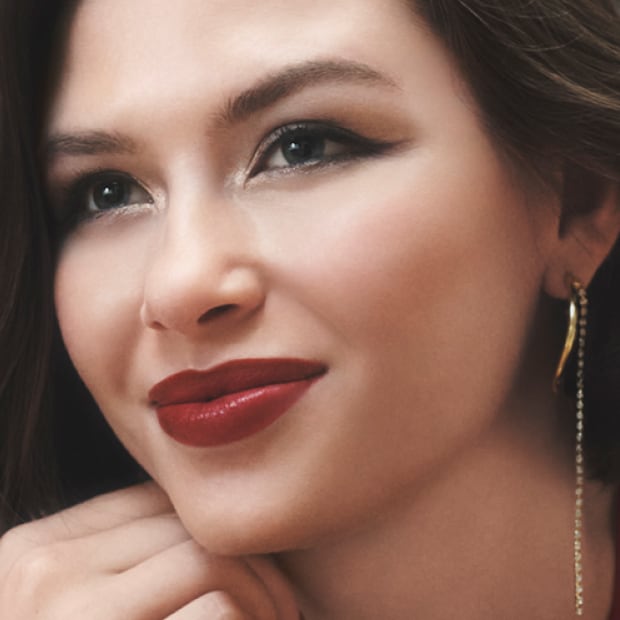 Model applying Skin Long-Wear Weightless Foundation to skin with a foundation brush